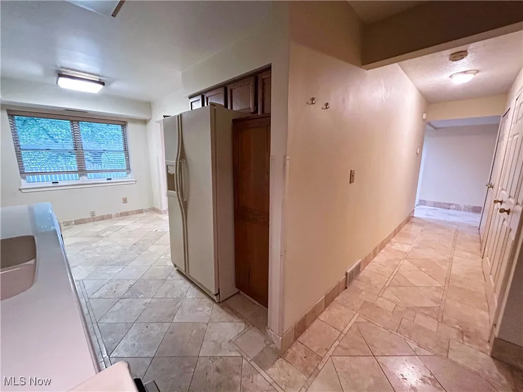 Kitchen featuring white appliances, large window, and light countertops