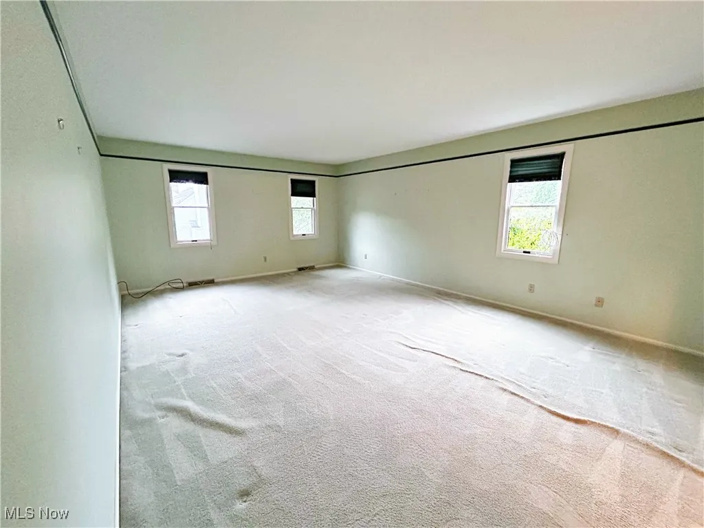 Carpeted master bedroom featuring windows