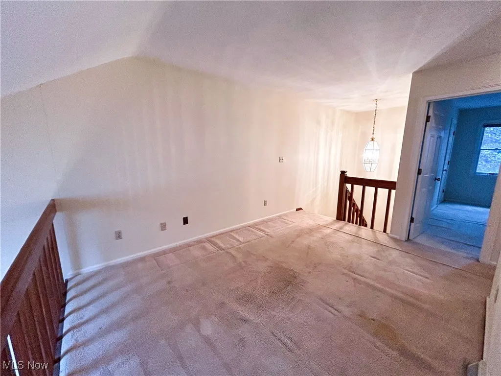 Loft featuring carpet and vaulted ceiling
