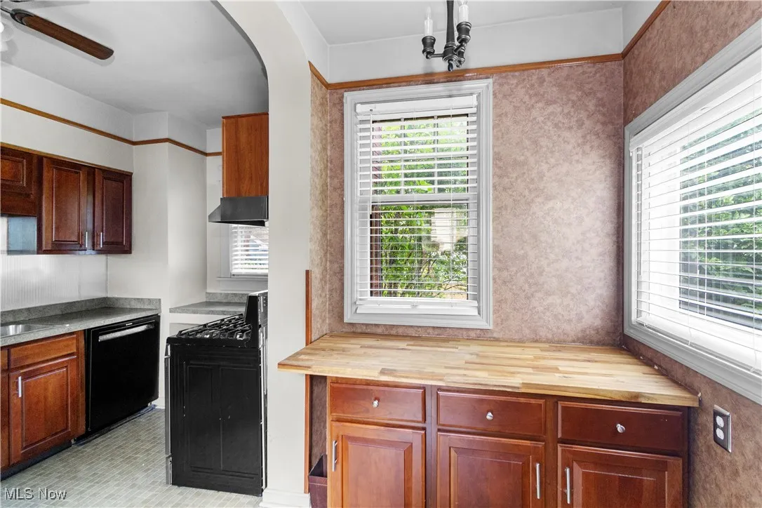 Kitchen with wooden counters, black gas range oven, dishwasher, and ceiling fan