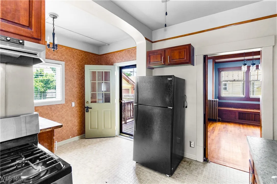 Kitchen featuring freestanding refrigerator, healthy amount of natural light, radiator, and extractor fan
