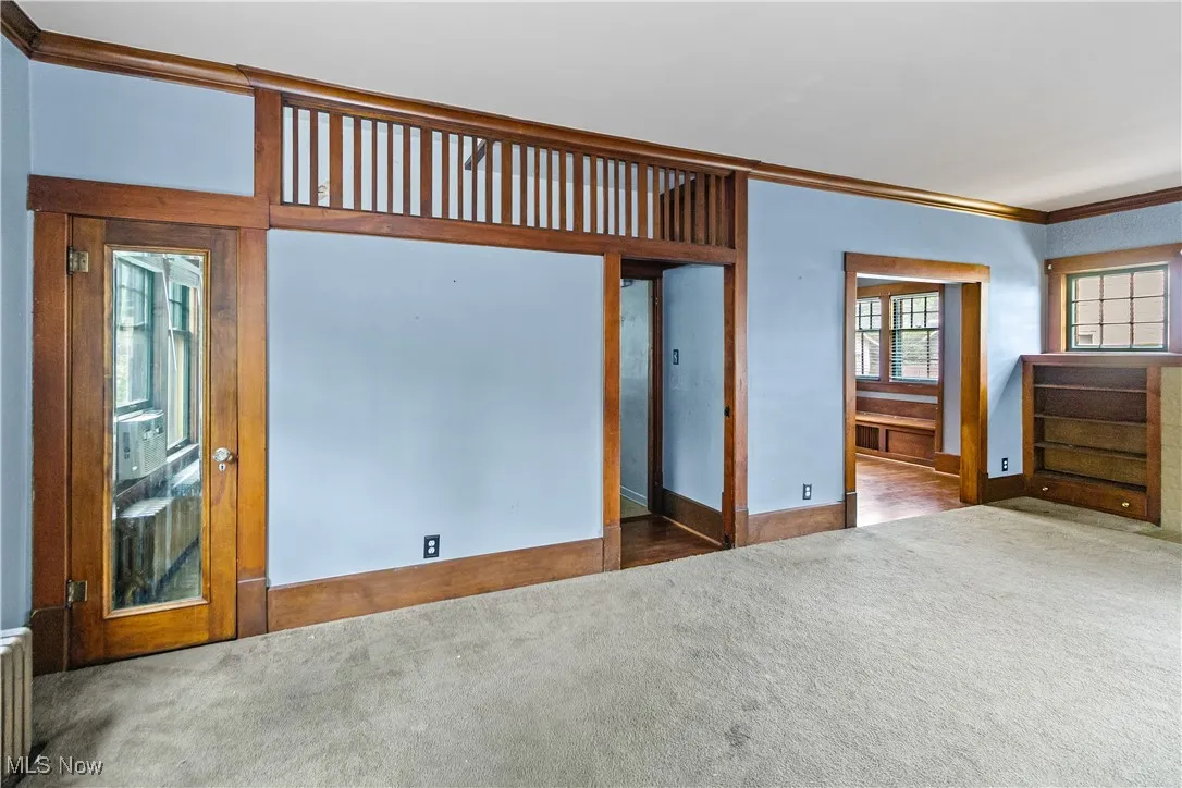 Unfurnished bedroom with carpet flooring, ornamental molding, and radiator