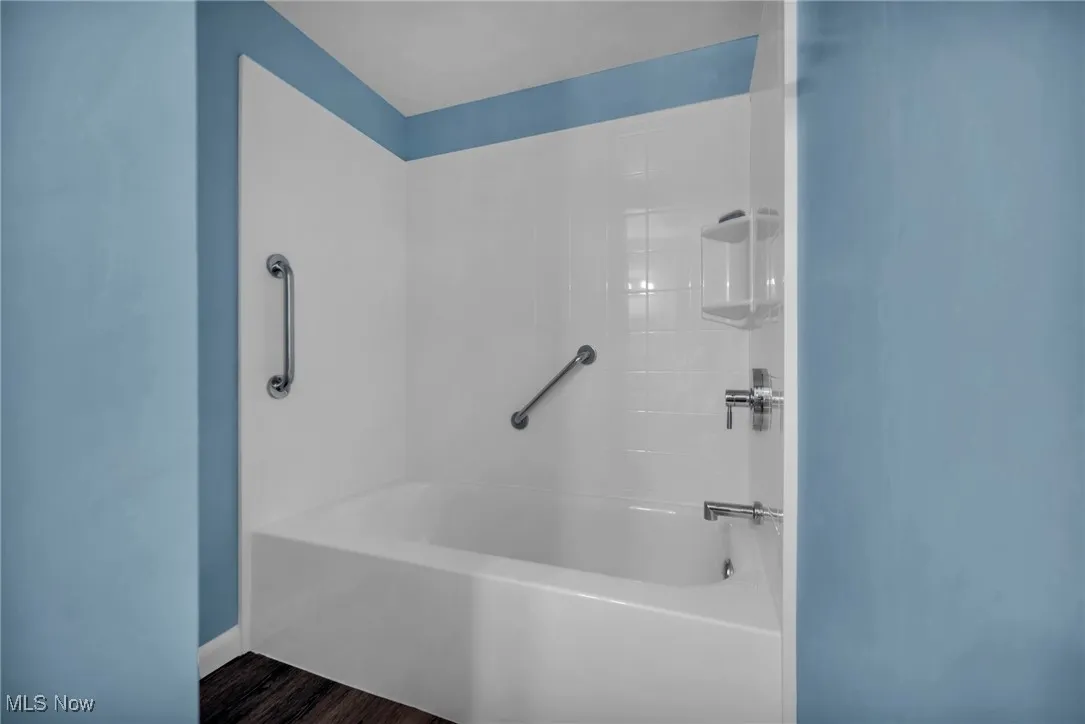 Bathroom with tub / shower combination and wood finished floors