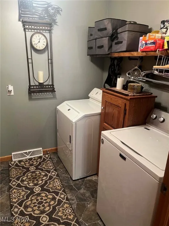 Laundry room with washer and clothes dryer and cabinet space