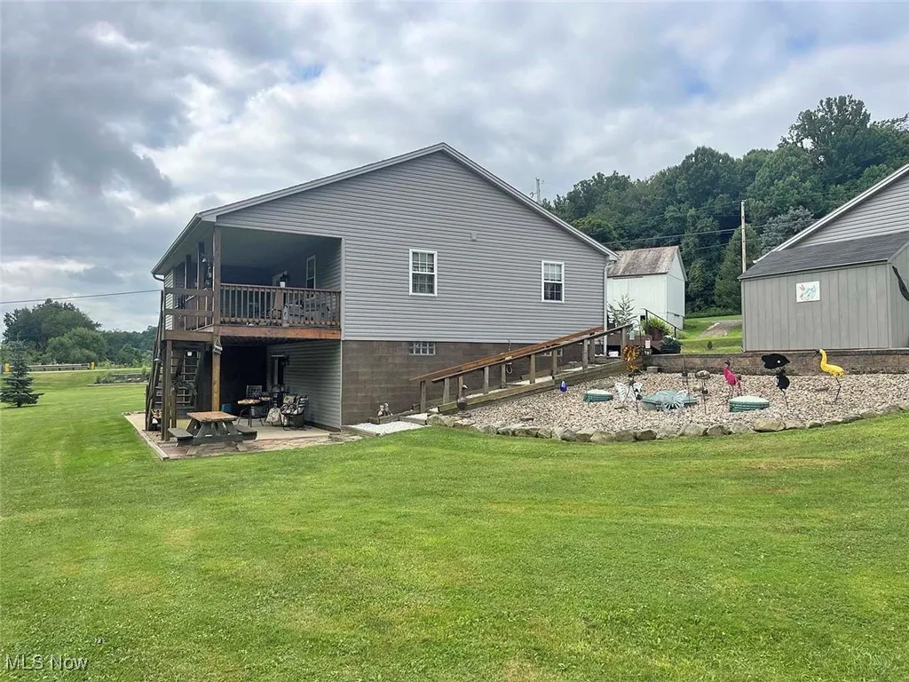 Back of house with a patio, a lawn, a deck, and stairway