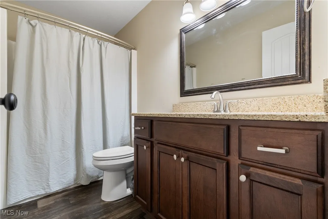 Full bath with vanity and wood finished floors