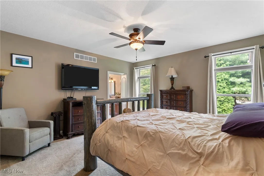 Carpeted bedroom featuring a ceiling fan