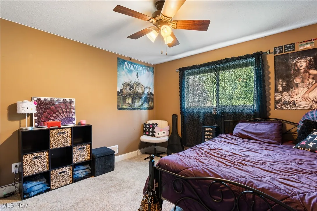 Carpeted bedroom with baseboards and ceiling fan