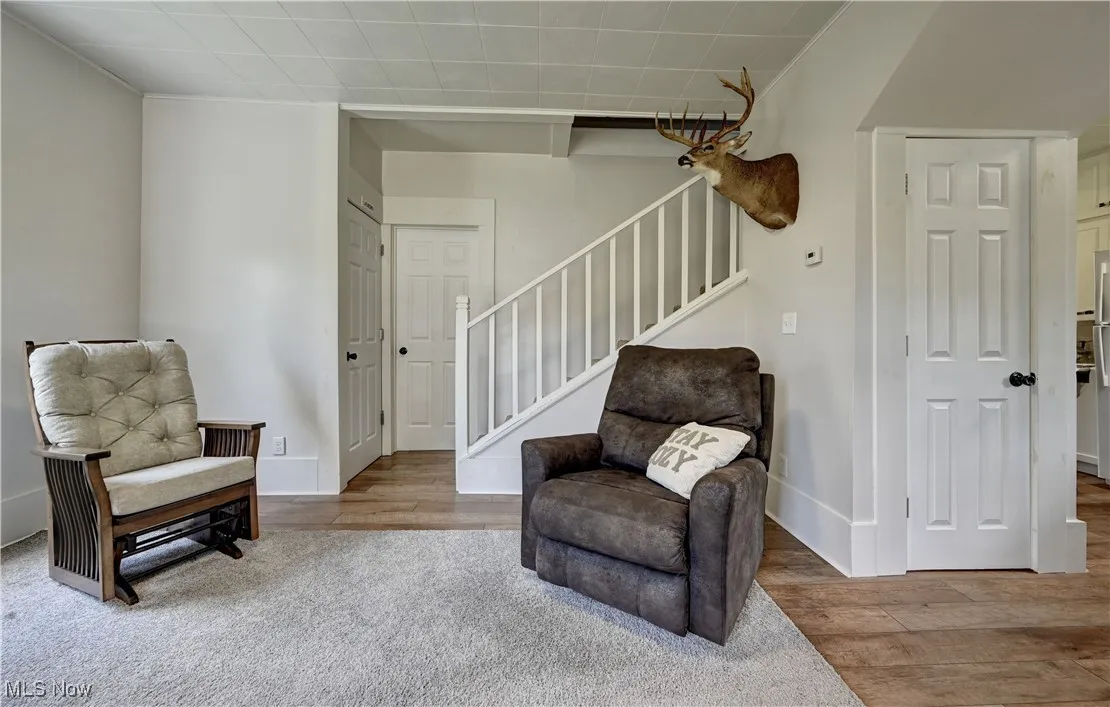 Living area with wood finished floors and stairway