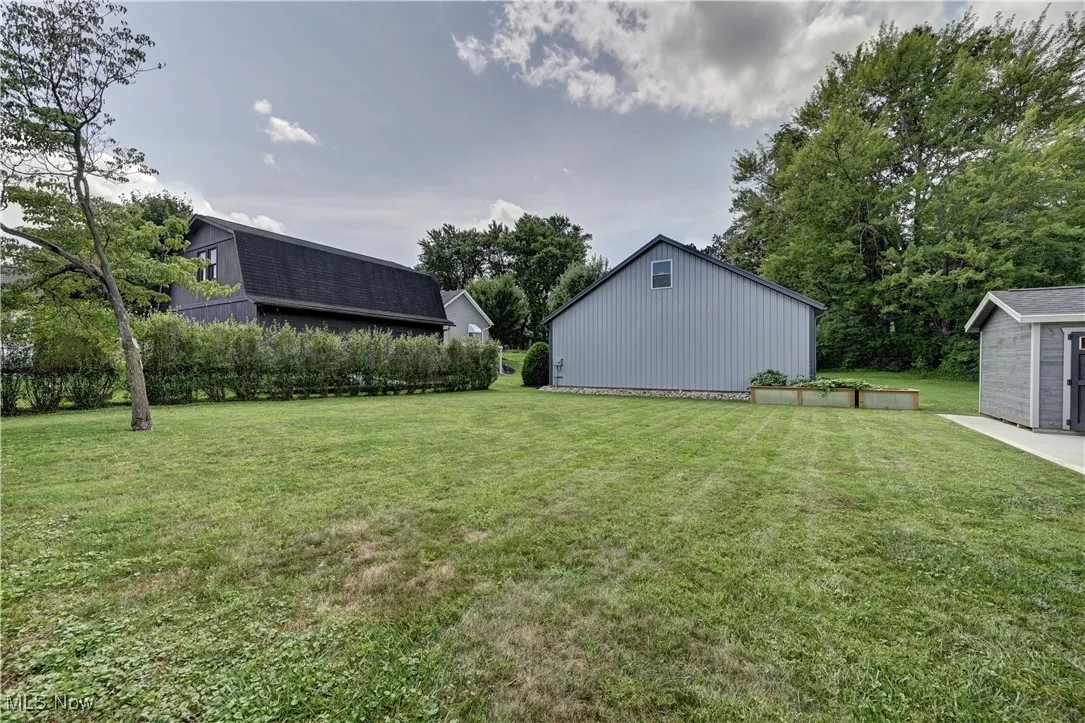View of grassy yard featuring a storage unit