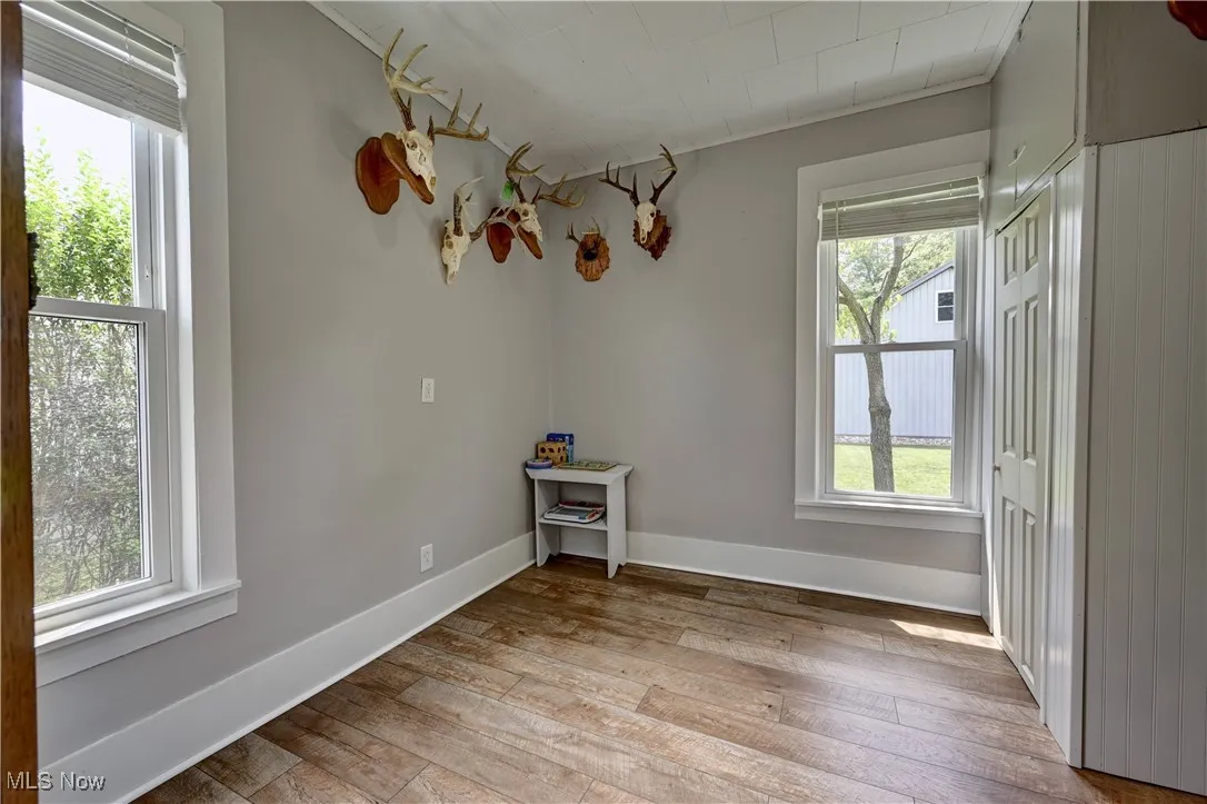 Empty room with wood-type flooring and healthy amount of natural light