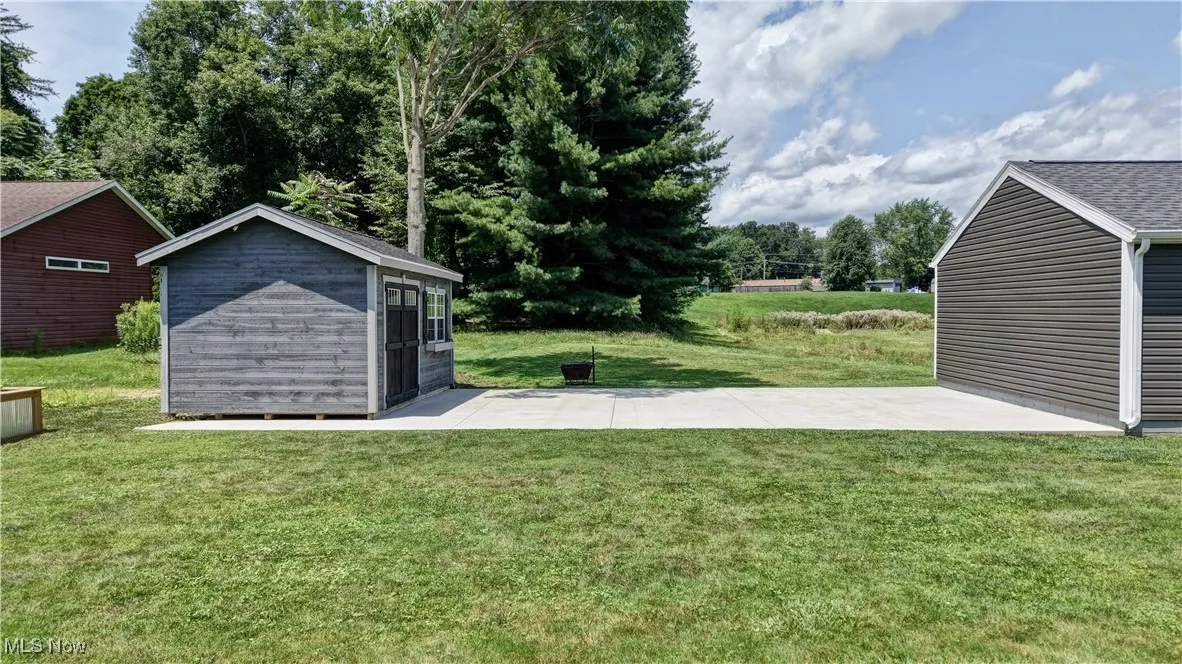 View of grassy yard featuring a storage shed