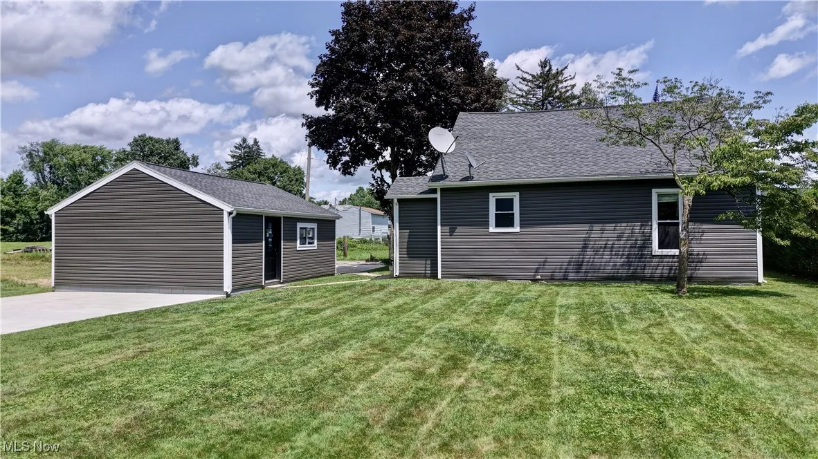 Rear view of property with a lawn and roof with shingles