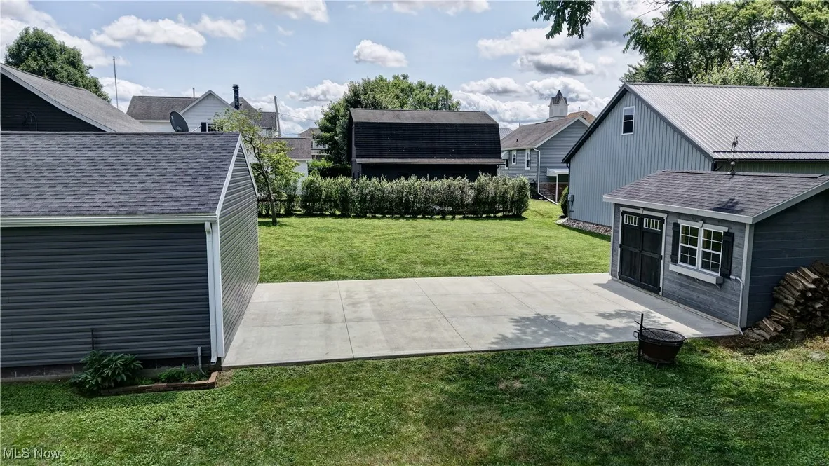 View of grassy yard with a patio area and a garage