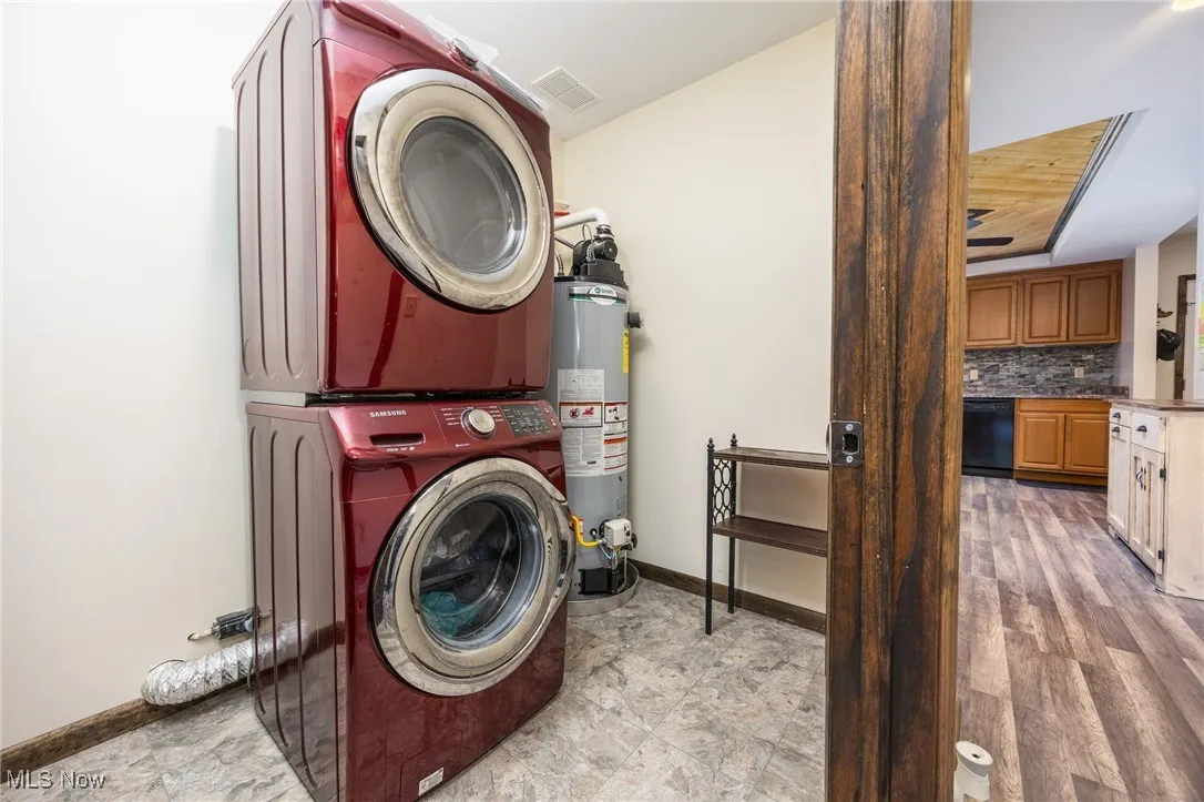 Laundry area featuring estacked washer and dryer and gas water heater