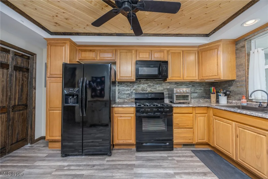 Kitchen featuring wooden ceiling, black appliances, ceiling fan, decorative backsplash, and recessed lighting