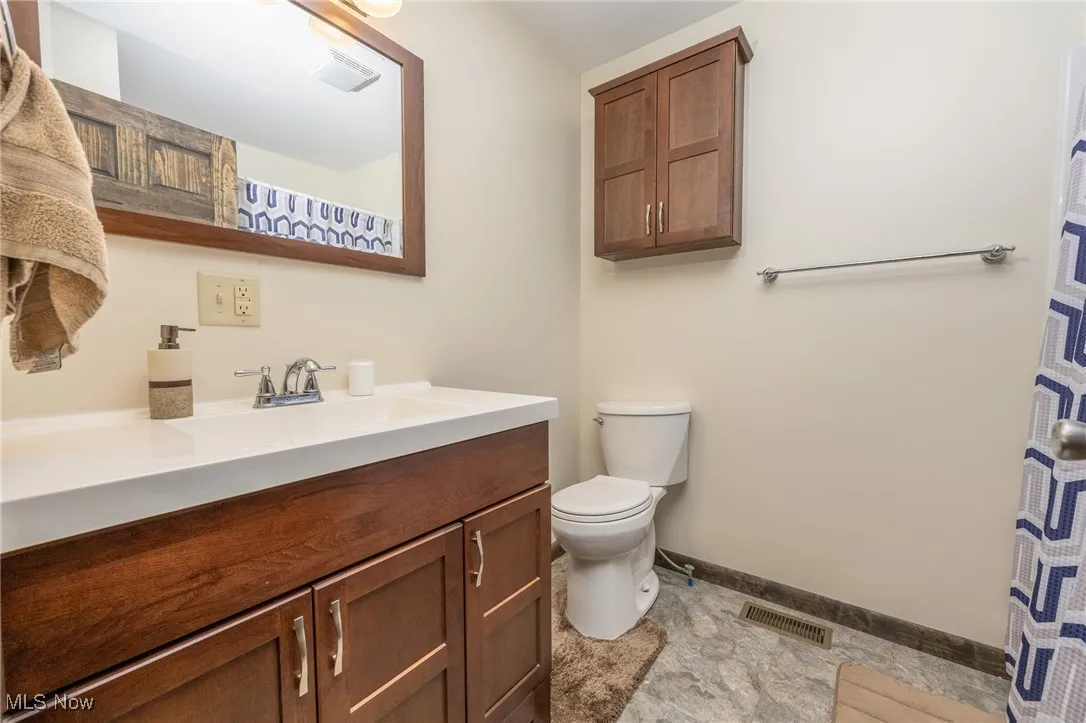 Full bathroom with vanity and curtained shower