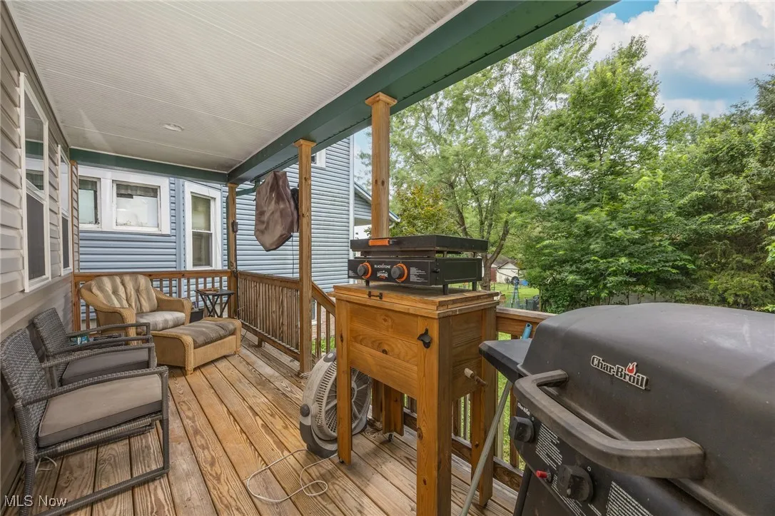Wooden terrace featuring a grill