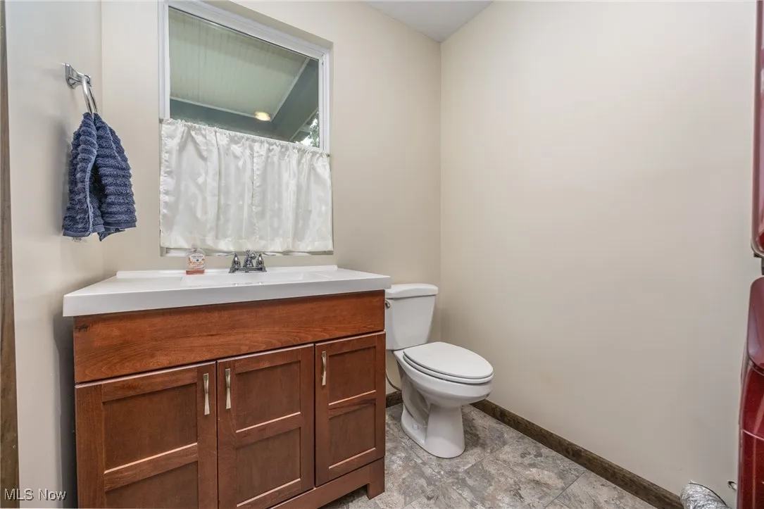 Full bath with baseboards and vanity