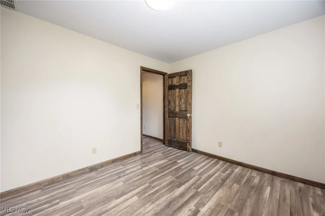 Unfurnished room with light wood-style floors and baseboards