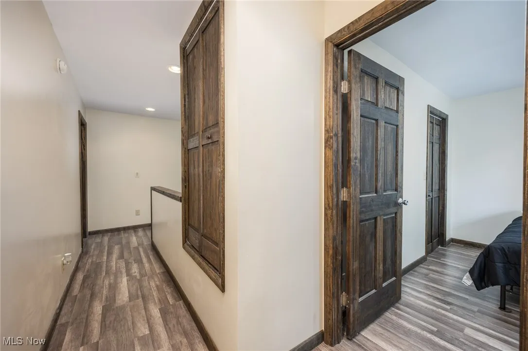 Corridor featuring wood finished floors and recessed lighting