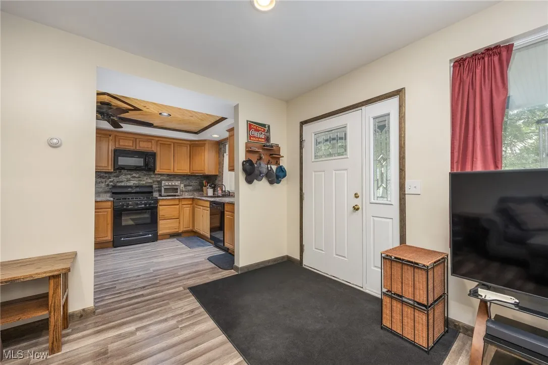 Foyer with light wood-style floors, recessed lighting, a ceiling fan, and a raised ceiling