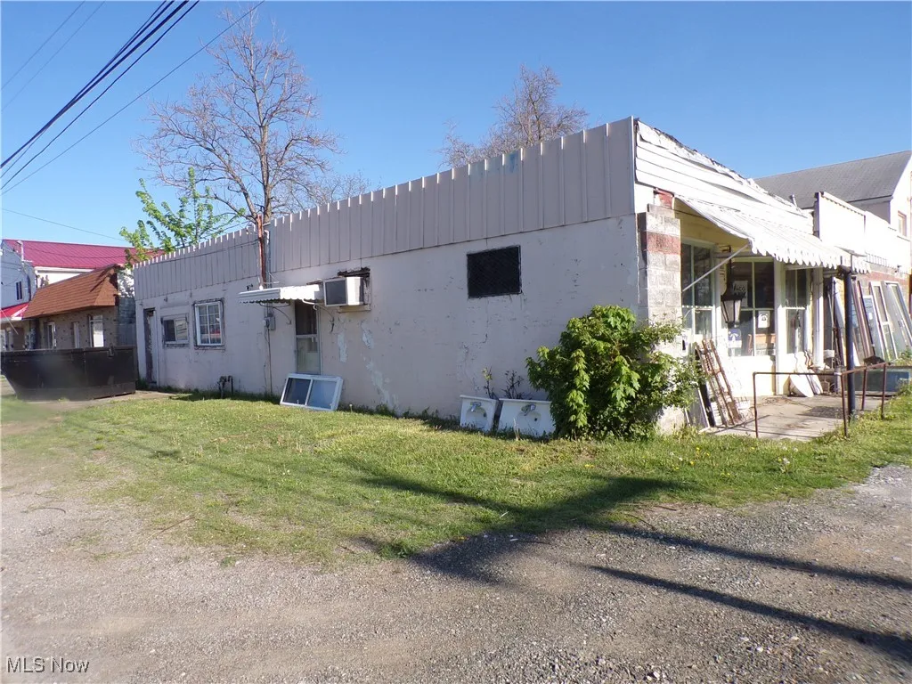 View of side of home with a lawn and stucco siding