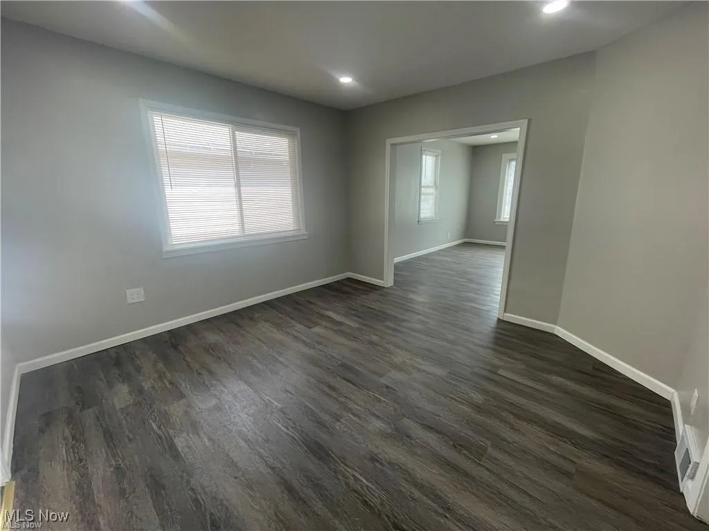 Spare room with dark wood-type flooring and recessed lighting