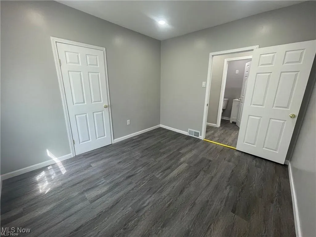 Unfurnished bedroom with dark wood-style flooring and recessed lighting