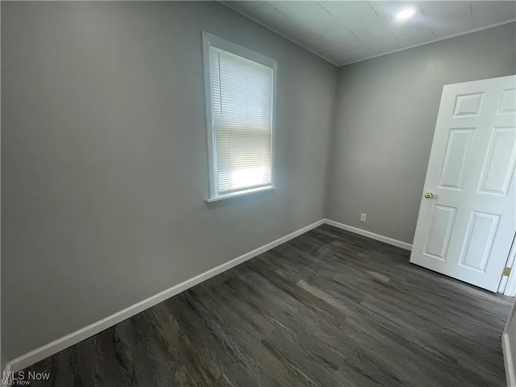 Unfurnished room with dark wood-style flooring and recessed lighting