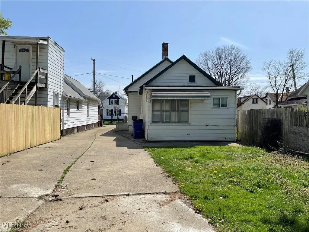Rear view of property with a chimney and driveway