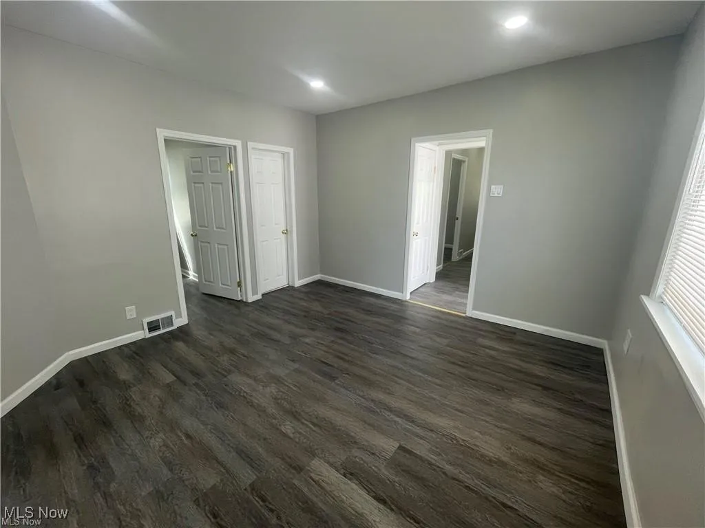 Spare room with dark wood finished floors and recessed lighting
