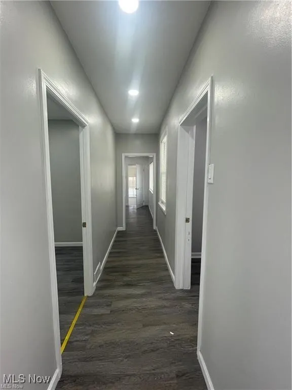 Hall featuring dark wood-style flooring and recessed lighting