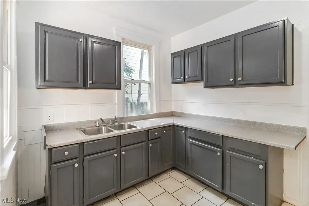 Kitchen with light countertops, gray cabinets, and light tile patterned flooring