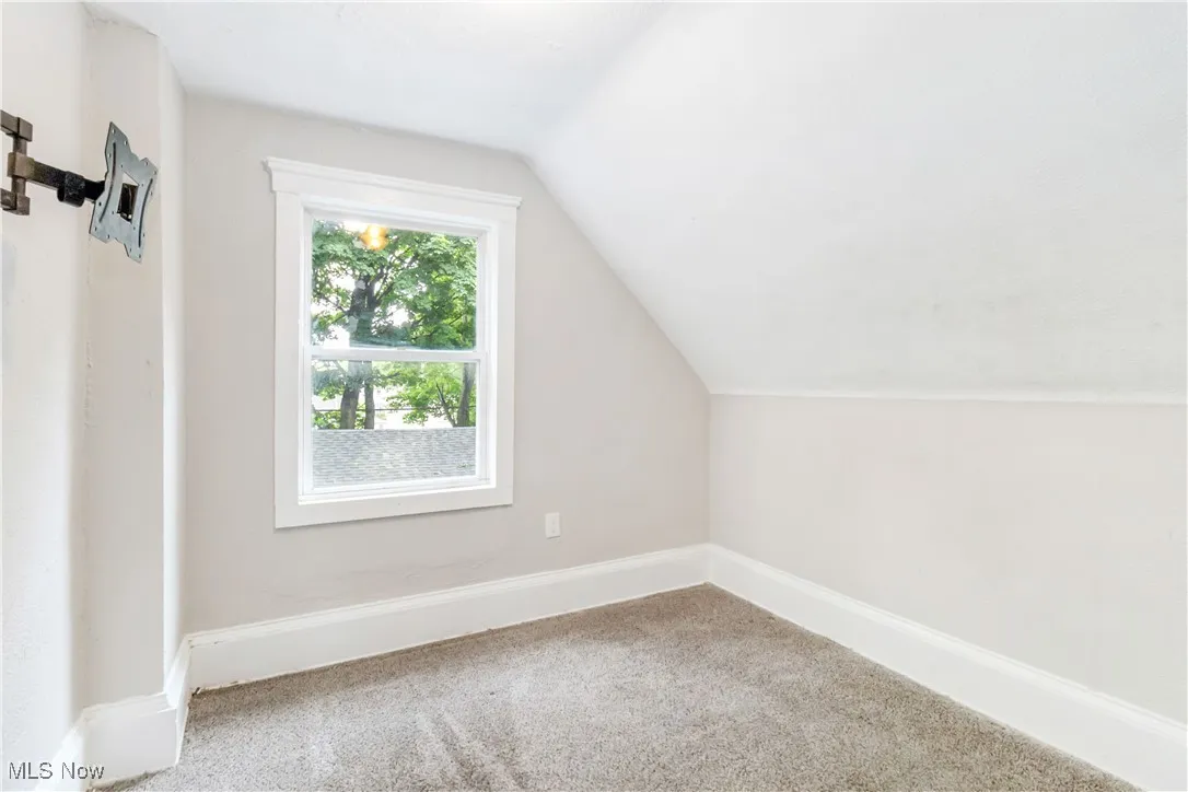 Additional living space with vaulted ceiling and carpet floors