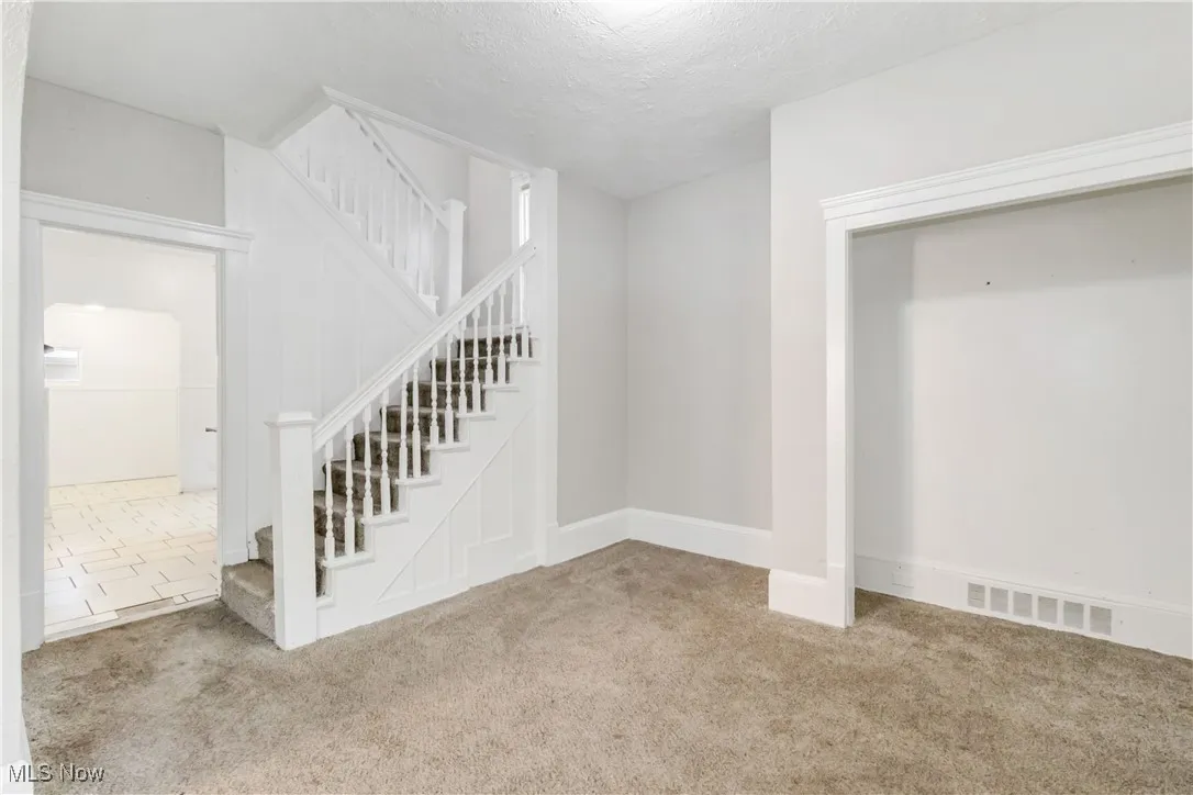 Stairway with carpet and a textured ceiling
