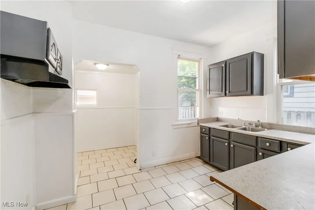 Kitchen with light countertops and light tile patterned flooring