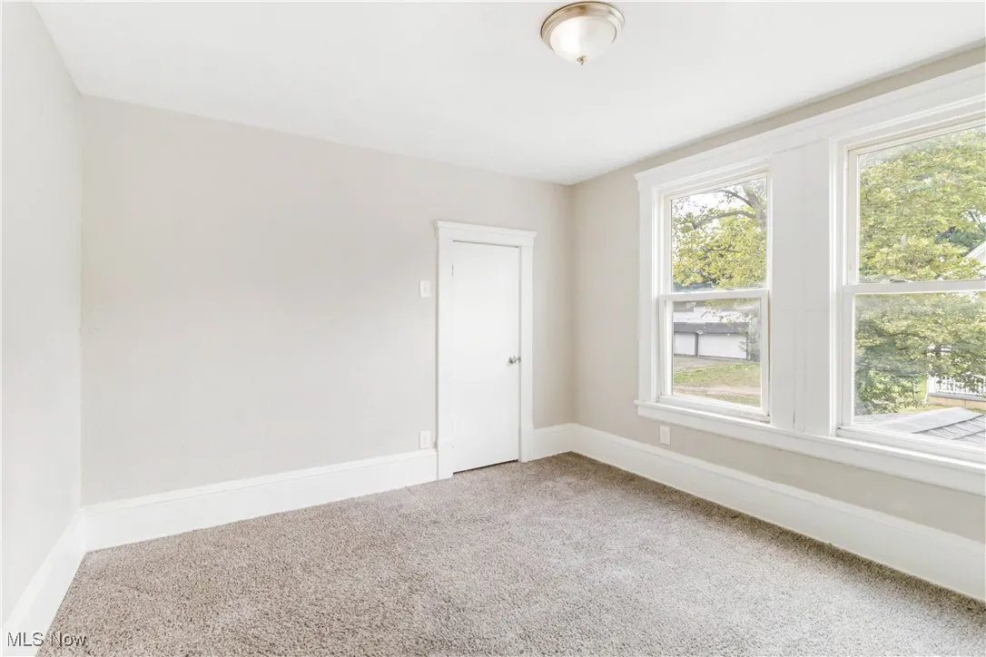 Unfurnished room featuring healthy amount of natural light and carpet
