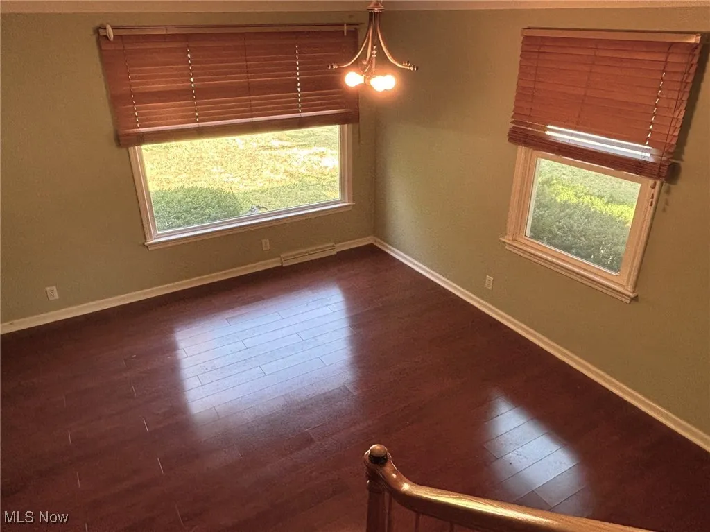 Spare room featuring dark wood-style floors