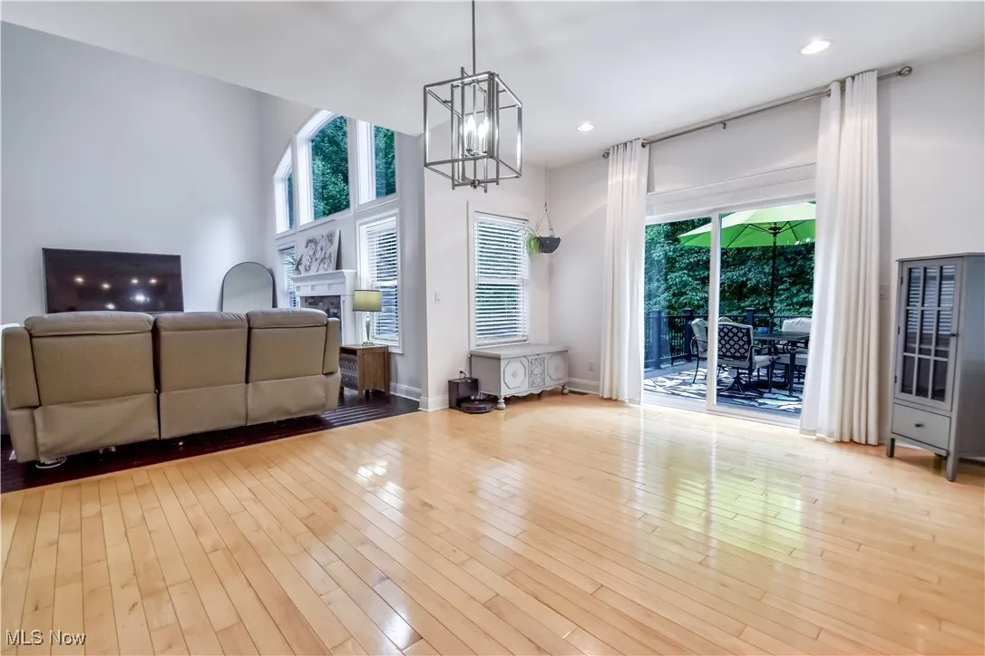 Living room with a chandelier, hardwood / wood-style flooring, a fireplace, and recessed lighting