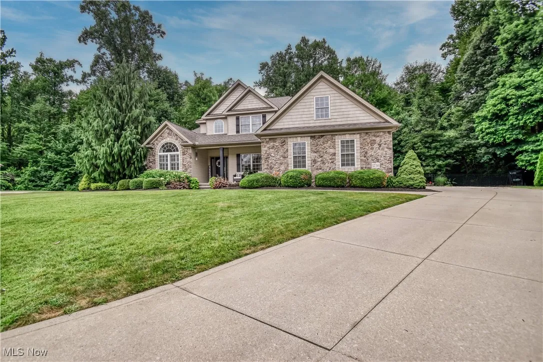 View of front facade featuring a front lawn, driveway, and a porch