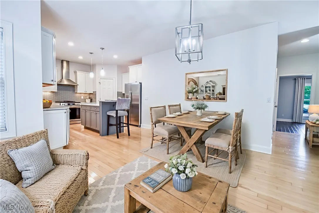 Living area with light wood-style floors, a chandelier, and recessed lighting - Virtually Staged