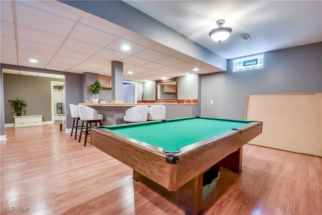 Rec room with bar area, wood finished floors, and billiards