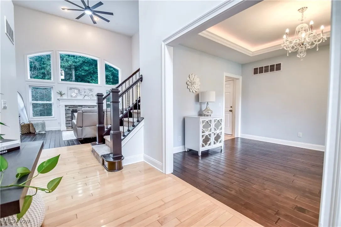Foyer entrance featuring a chandelier, stairs, a fireplace, and wood-type flooring