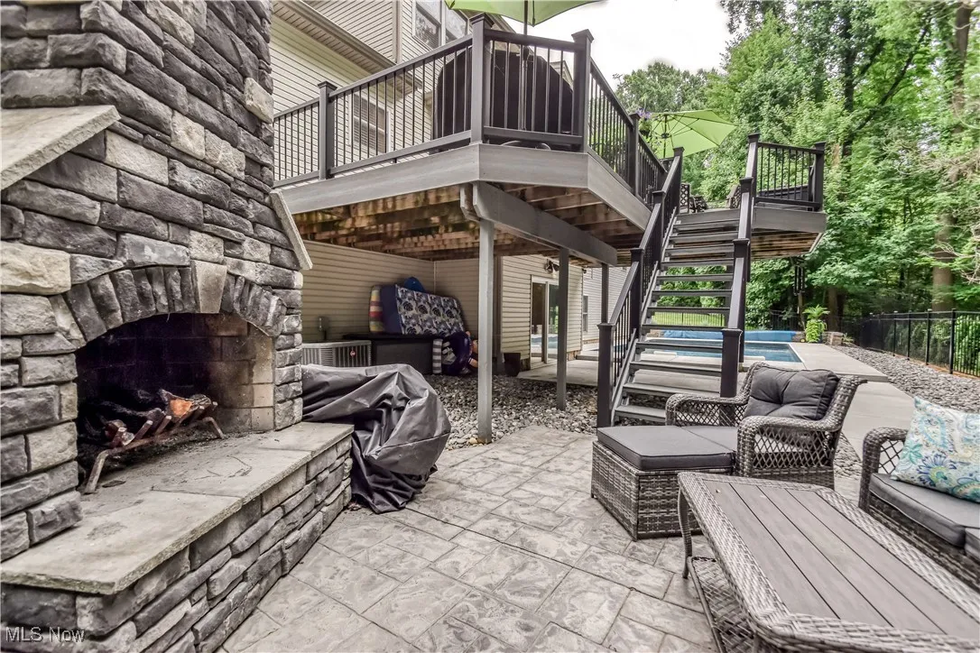 View of patio / terrace featuring stairway, an outdoor living space with a fireplace, and a wooden deck