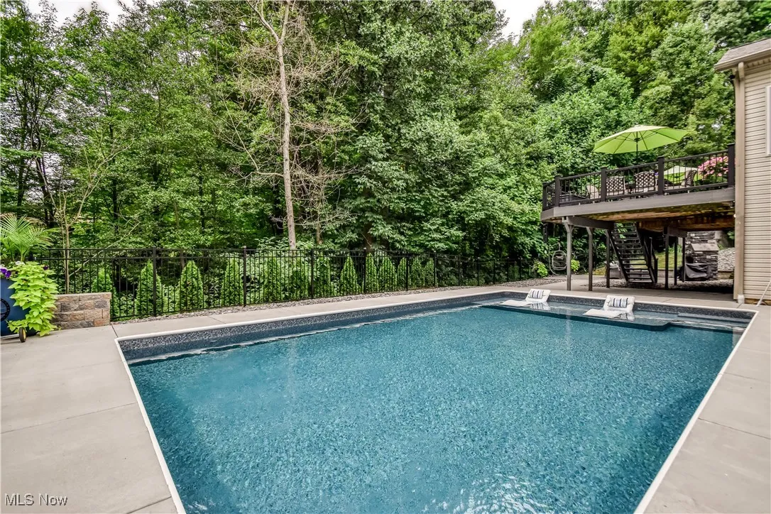 View of swimming pool with stairs, a deck, and a patio area