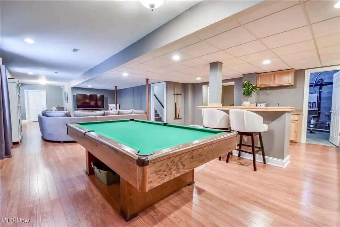 Game room with light wood-style floors, bar, billiards table, and recessed lighting