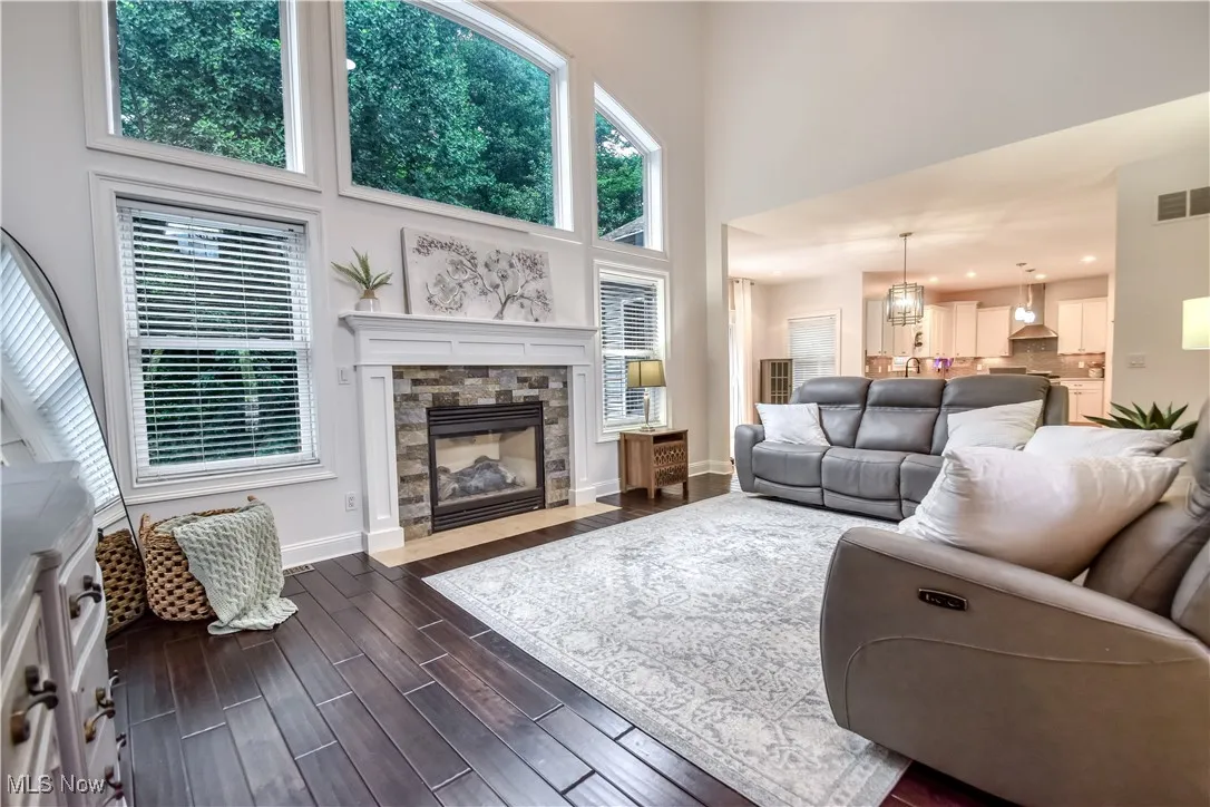 Living room featuring a towering ceiling, dark wood-type flooring, and a fireplace
