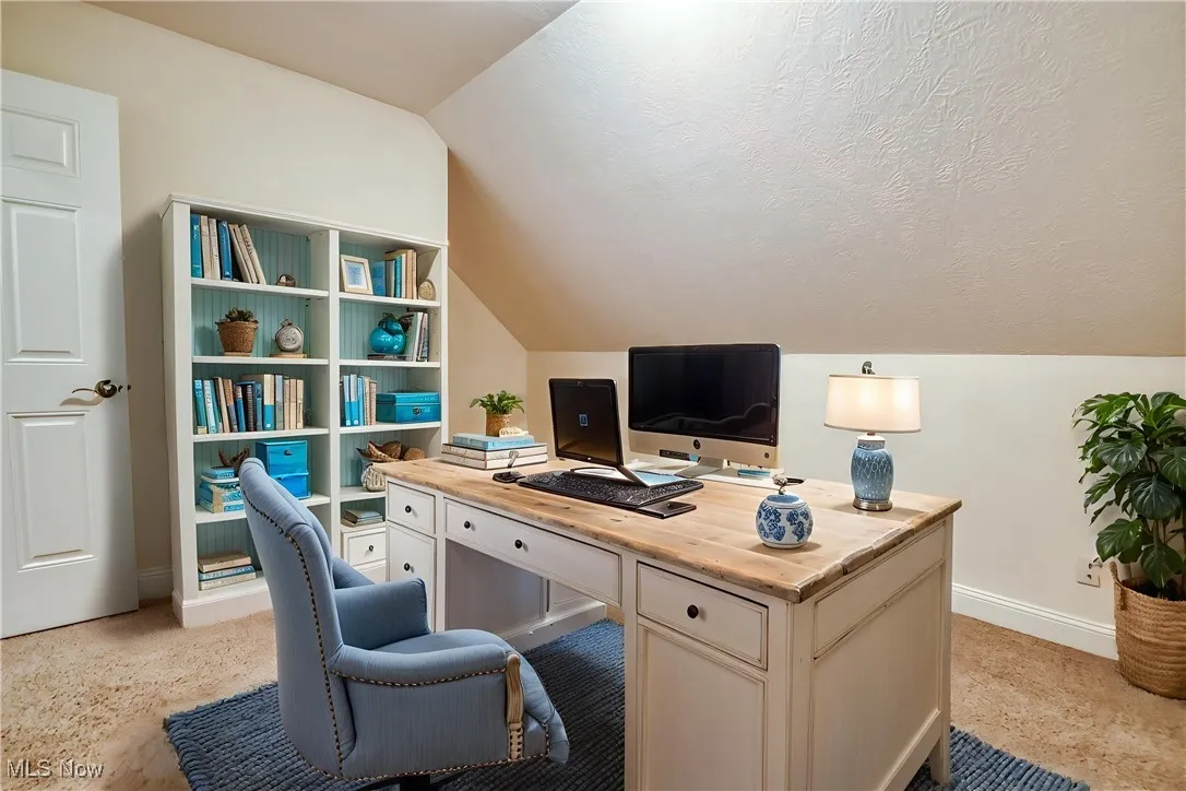 Home office featuring lofted ceiling and baseboards - virtually staged