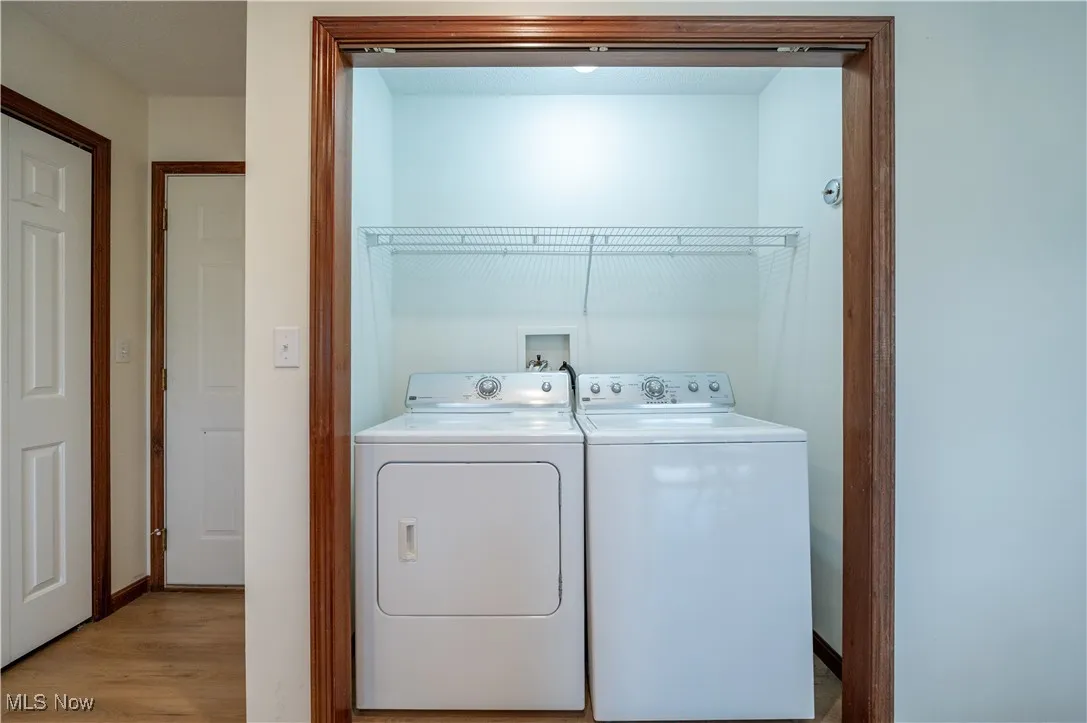 Laundry room with washer and dryer and light wood-style flooring